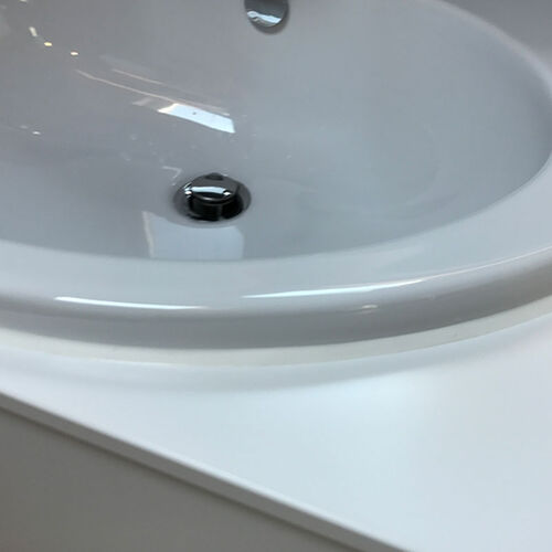 Farblich perfekt angepasste Anschlussfuge zwischen Waschbecken und Waschtisch.